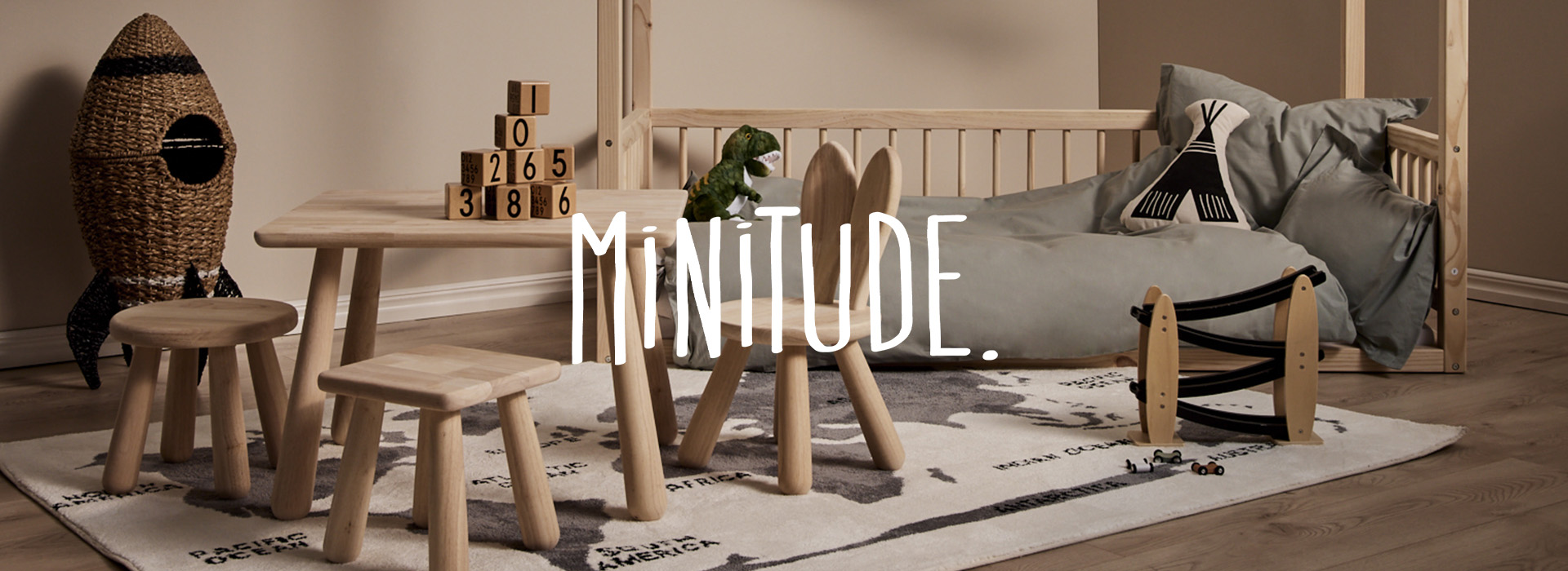 Kinderzimmer mit Holztisch, Stühlen und Bett. Raketenregal und Spielzeug.