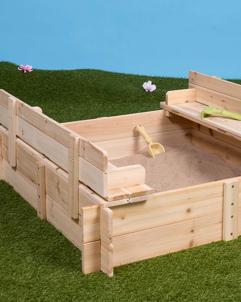 Kind spielt in Holzkiste, die wie ein Boot geformt ist.