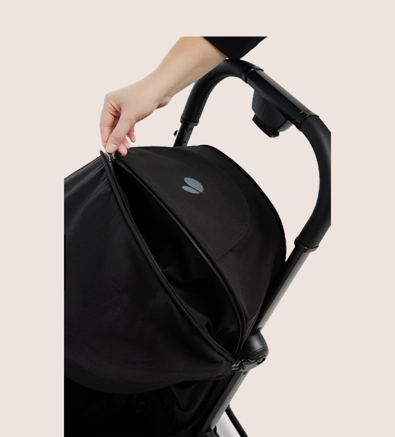 Hand justiert schwarzen Kinderwagendeckel.