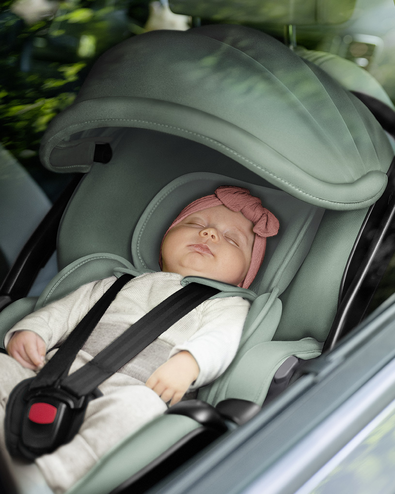 Baby schläft in einem Autositz im Auto.
