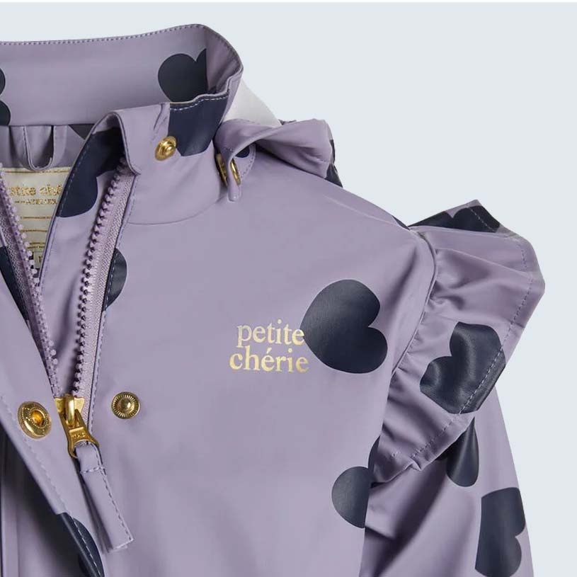 Lila Jacke mit schwarzen Herzen und dem Text 'petite chérie'.
