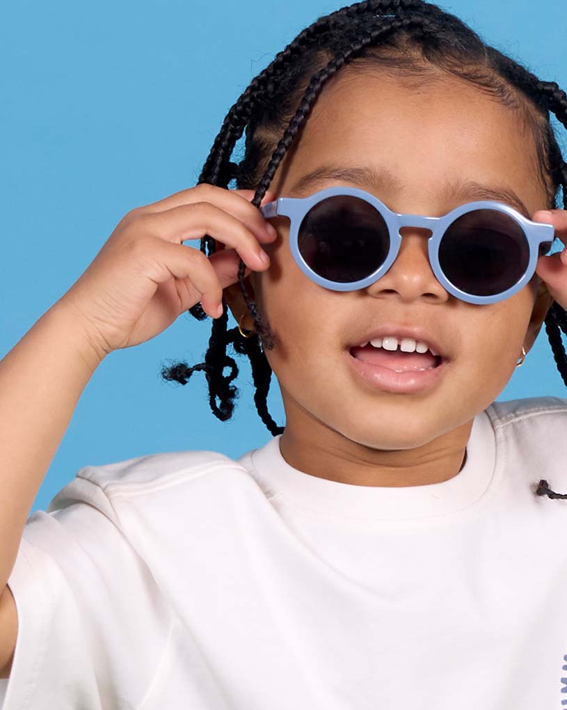 Kind mit Sonnenbrille auf Stroh, grüne Sprechblase: 'Neu!'