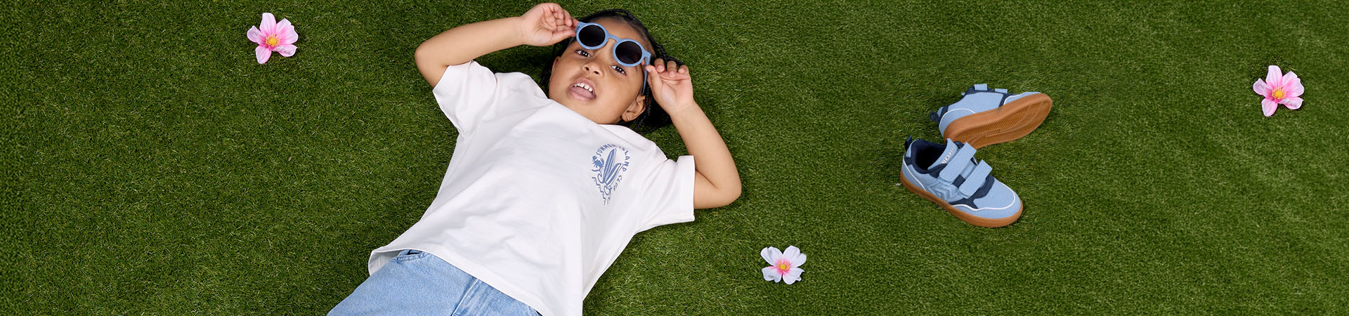 Frau mit zwei kleinen Kindern im Freien nahe Fahrradanhänger und Gebäude im Hintergrund.