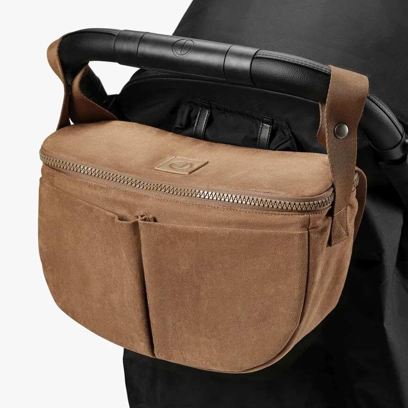 Babyprodukte und Tascheninhalt auf hellem Hintergrund.