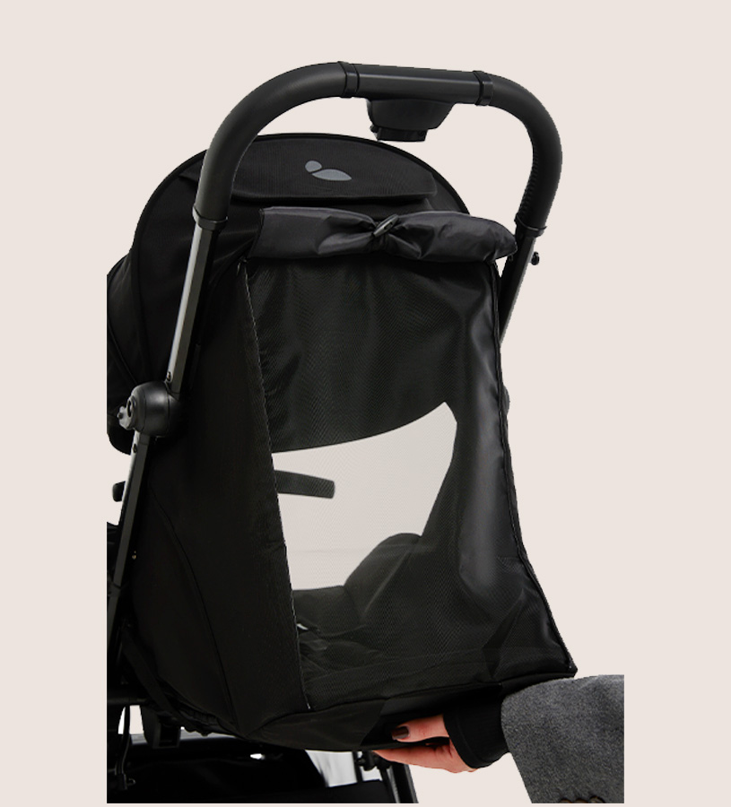 Ein schwarzer Kinderwagen mit einer Hand, die das Verdeck anpasst.