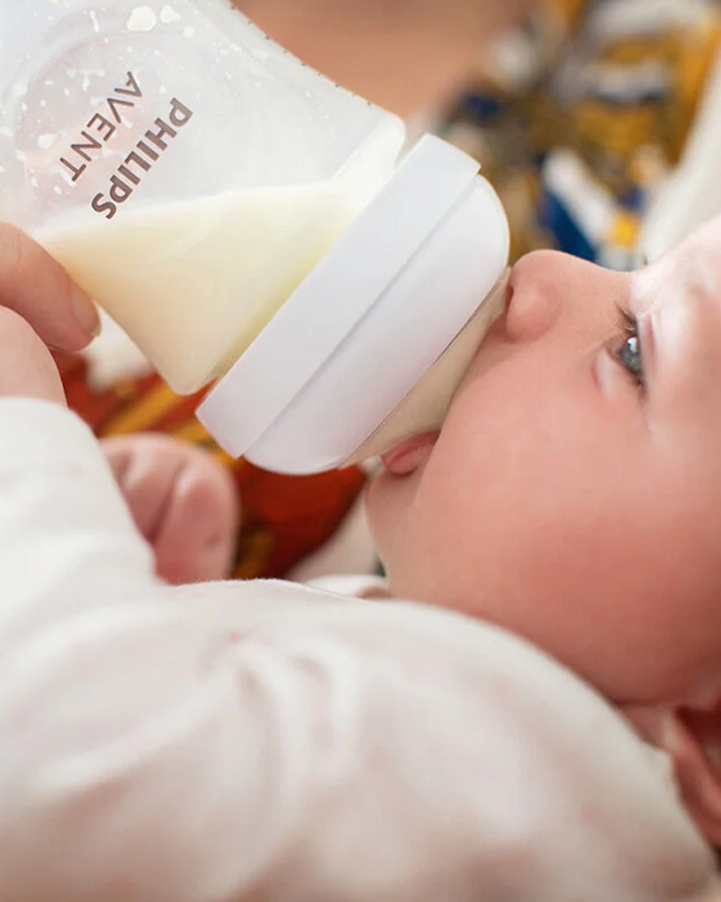 Baby trinkt Milch aus einer Flasche.